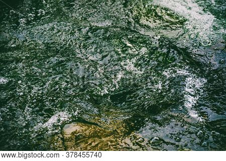 Green Water Surface With Bubbles Close-up. Background Of Green Soda Drink Water. Nature Texture Of S