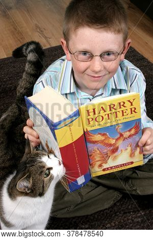 A Boy In Glasses Reading Harry Potter And The Order Of The Phoenix With His Cat, Taken On The 11th D