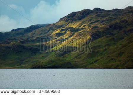 Mountain Slope Next To The Lake Illuminated By The Sun In Summer. Loch Morar, Highland, Scotland, Uk