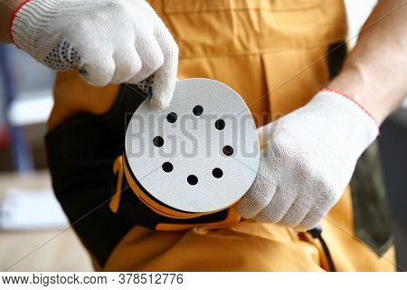 Close-up Of Male Worker Changing Disc On Sander Machine. Cropped Picture Of New Professional Instrum