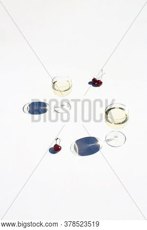 Glasses Of White Wine And Some Sweet Cherries On White Background For Concept Trendy Design. Hard St