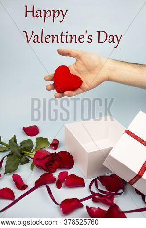 Valentine's Day Concept Valentine's Day. Male Hand Holds A Red Heart. White Gift On A Background Of 