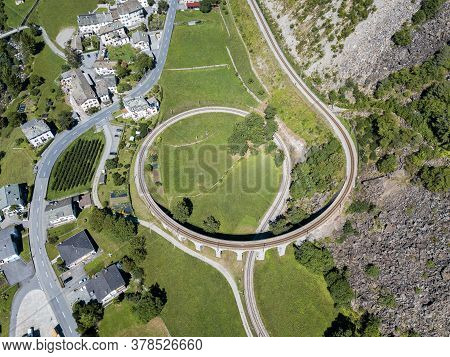 Aerial Drone Image Of The Brusio Spiral Viaduct - A Single-track Nine-arched Stone Spiral Railway Vi