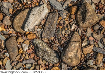 Looking Down On A Dry Part Of The Riverbed That Has Several Kinds Of Colorful Rocks And Stones With 