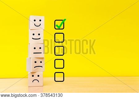 Customer Service Evaluation And Satisfaction Survey Concepts. Images Of Emoticons On Wooden Cubes. Y