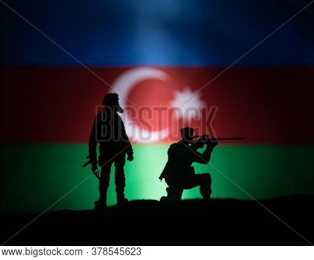 Azeri Army Concept. Silhouette Of Armed Soldiers Against Azerbaijani Flag. Creative Artwork Decorati