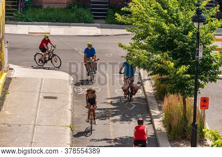 Montreal, Canada - 28 July 2020: People Riding Bikes On A Cycle Path, On Arcade Street