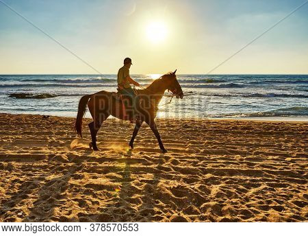 Arsuf, Israel - July 22, 2020: Horseback Riding Along The Mediterranean Sea Coast At Sunset.