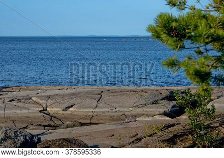 Clear Sky, Blue Water And Stones From Gabbro Diabase On The Shores Of Lake Ladoga.