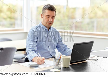 remote job, business and people concept - middle-aged man with calculator, papers and laptop computer working at home office