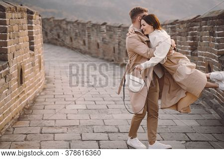 Young Couple Running And Twirling At The Great Wall Of China