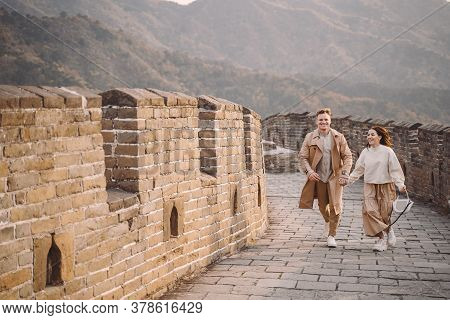 Young Couple Running And Twirling At The Great Wall Of China