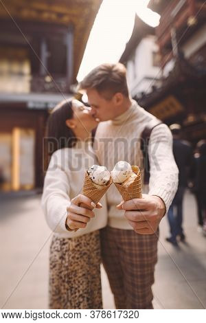 Newlywed Couple Eating Ice Cream From A Cone On A Street In Shanghai Near Yuyuan China.