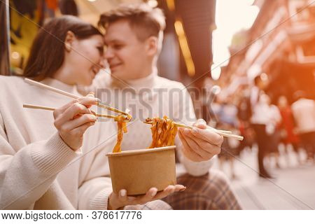 Newlywed Couple Eating Noodles With Chopsticks In Shanghai Outside A Food Market
