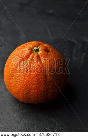 One Big Whole Orange Mandarin On Black Background. Darkmood Food Pfotography.