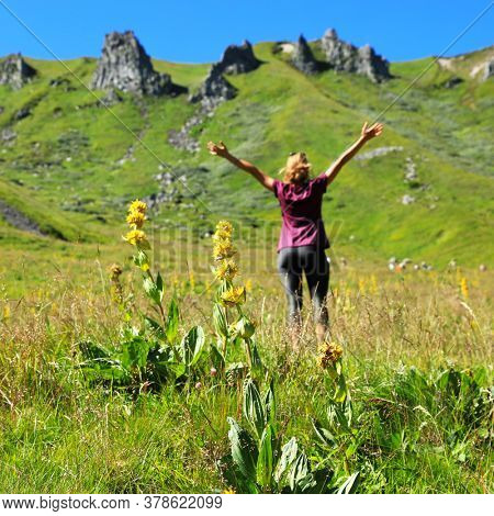 woman happy, arm in air, beautiful mountain