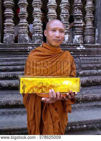 Angkor Wat, Siem Reap, Cambodia, April 6, 2016: A Buddhist monk receives an offering in the temple Angkor Wat in Siem Reap, Cambodia.
