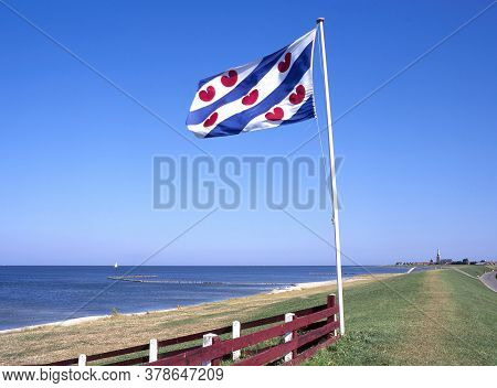 Ijsselmeer Coast With The Flag Of Friesland And At The Horizon Hindeloopen, Friesland, Netherlands