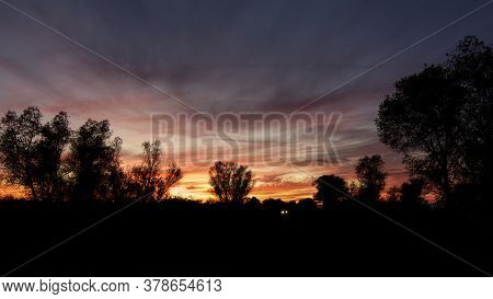 The Headlights Of A Car In California's Central Valley's Sunset, Featuring A Multitude Of Colors And