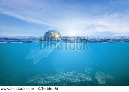 Creative Background, World Wrapped In Plastic Floating In The Ocean, A Bottle In The Water. The Conc