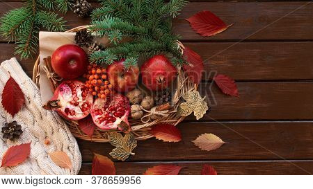 Apples, Pomegranate, Cinnamon, Cones, Walnuts, Fallen Leaves On A Wooden Background. Autumn Composit