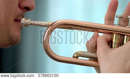 A Young Man Plays The Trumpet. Hands Of Musician. Close Up View.