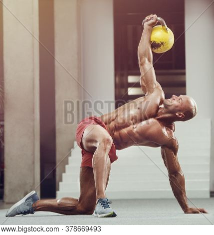 Bodybuilder Pumping Up Chest Muscles With Kettlebell