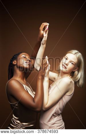 Two Pretty Girls African And Caucasian Blond Posing Cheerful Together On Browm Background, Etnithity