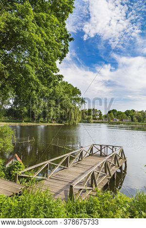 Summer View  On The Lake With A Wooden Bridge. Landscape Park In The Palace And Park Ensemble In Vil