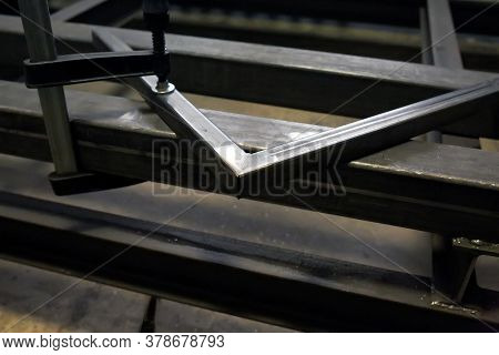 Grinding A Metal Corner In A Locksmith Workshop After Welding. Stripping The Seam. Clamp
