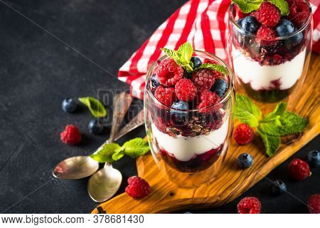 Parfait With Granola, Jam And Fresh Berries In The Glass Jar. Close Up. Healthy Dessert Or Snack.