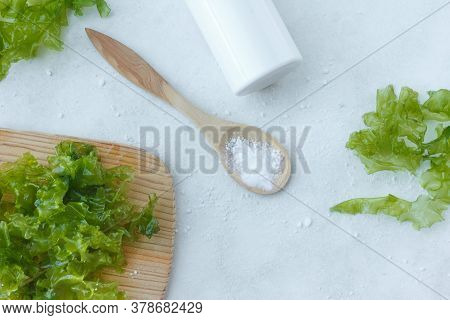 Fresh Leaves Of Edible Ulva Seaweed On A Wooden Board, And Seaweed Powder On A Wooden Spoon