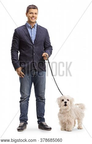 Full length portrait of a young man with a maltese poodle dog on a lead isolated on white background