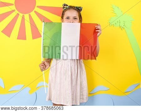 Little Girl On A Bright Background With Italian Flag. The Concept Of Summer, Beach Holidays And Vaca