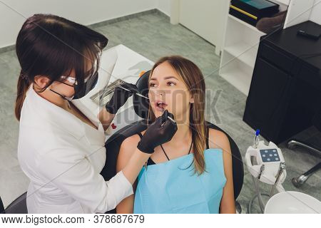 Dentist Detects The Carious Teeth Of The Patient On The Dentists Chair.