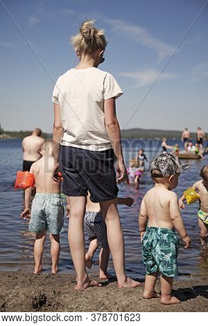 Umea, Norrland Sweden - June 25, 2020: Young Mother With Children On The Beach