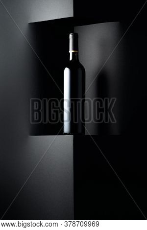 Unopened Bottle Of Red Wine On A Black Background. Copy Space For Your Text.