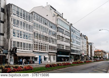Corunna, Spain - July 20, 2020: View Of Marina Avenue With Unknown People Walking And Houses With Fa
