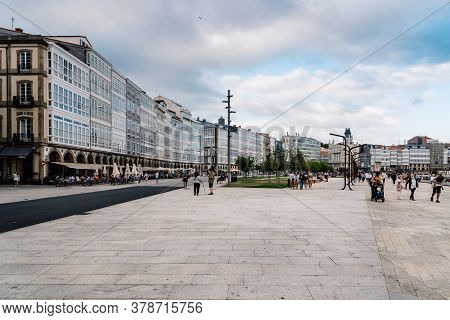 Corunna, Spain - July 20, 2020: View Of Marina Avenue With Unknown People Walking And Houses With Fa