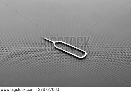 Sim Card Ejector Tool On Black Texture Background
