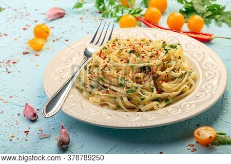 Linguini Pasta With Hot Chili Is Served With Garlic And Parsley Sauce On A Ceramic Plate. Italian Cu