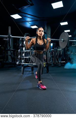 Side View Of Brunette Female Bodybuilder With Long Braids Doing Lunges Using Barbell. Srtong Woman W