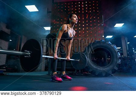 From Bellow View Of Brunette Female Bodybuilder With Braids Doing Deadlift Using Barbell. Srtong Wom
