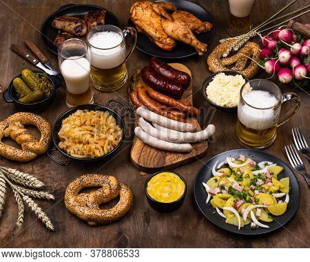 Oktoberfest Dishes: Beer, Pretzel, Sausage, Stewed Cabbage, Potato Salad Half Of Chicken And Ribs