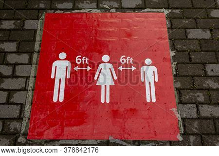 Red Sign On The Floor That Informs People To Keep A Social Distance. Sign Informing People To Keep 6