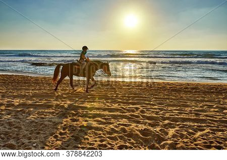 Arsuf, Israel - July 22, 2020: Horseback Riding Along The Mediterranean Sea Coast At Sunset.