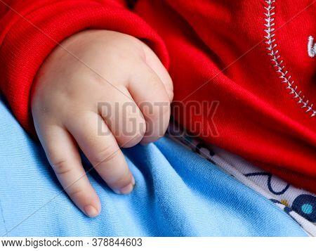 Close Up Shot Of The Cute Hands Of A Baby In Red Dress  While Sleeping