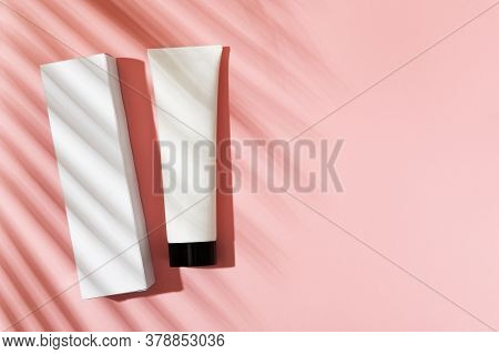 White Tube With Foam, Hand And Body Cream With Cardboard Packaging On A Pink Background. Cosmetic Be