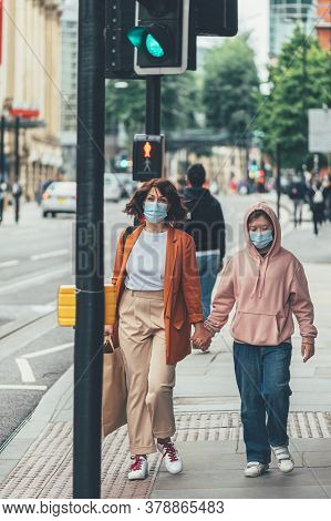 Mum And Daughter In Face Mask Are Shopping In City Centre Of Manchester, England, Uk , New Normal