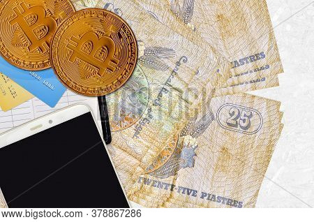 25 Egyptian Piastres Bills And Golden Bitcoins With Smartphone And Credit Cards. Cryptocurrency Inve